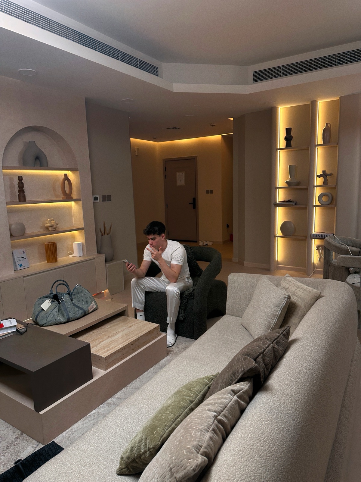 Danil in Hotelsuite mit Reisetasche und Telefon
